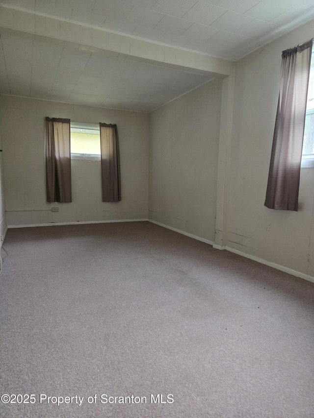 unfurnished room featuring carpet floors and baseboards