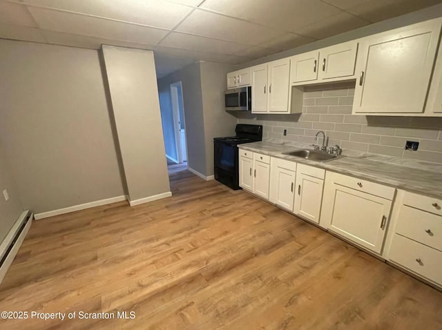 1034 Plane St, Avoca, PA 18641 - kitchen with a sink, baseboards, stainless steel microwave, black range with electric cooktop, and white cabinetry