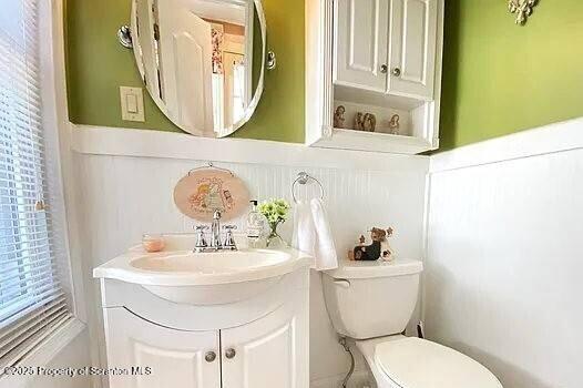 1747 Monsey Ave, Scranton, PA 18509 - half bathroom featuring toilet, vanity, and a wainscoted wall
