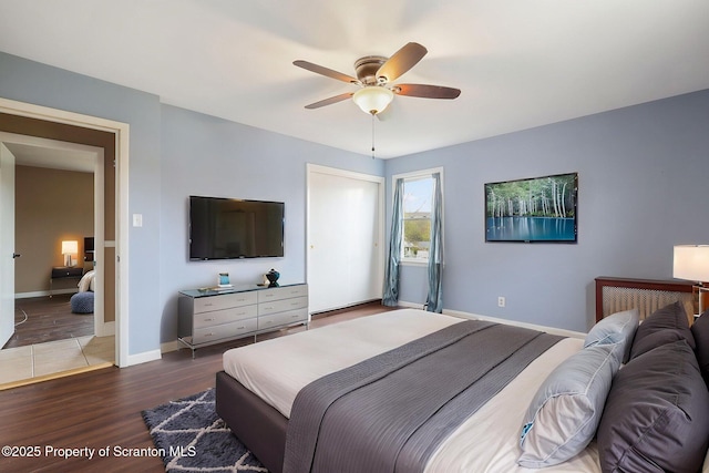 bedroom featuring wood finished floors, a ceiling fan, and baseboards