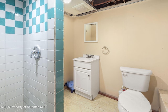 bathroom featuring tiled shower, tile patterned floors, vanity, and toilet