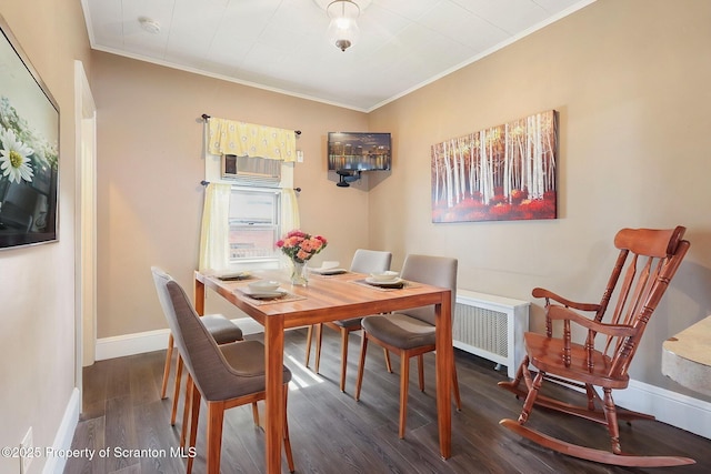 dining area featuring wood finished floors, crown molding, and baseboards