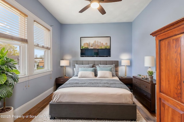 bedroom featuring baseboards, a ceiling fan, and wood finished floors
