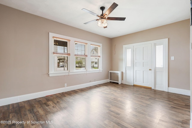 unfurnished bedroom with wood finished floors, baseboards, ceiling fan, and radiator