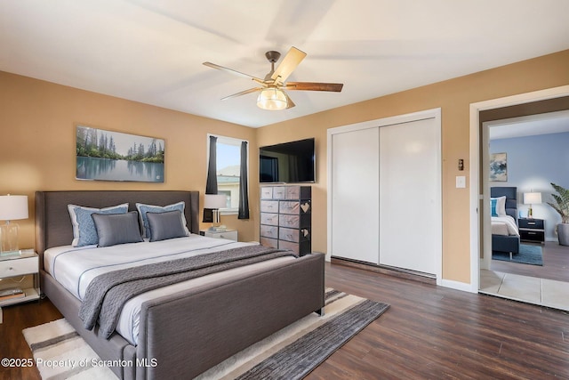 bedroom with wood finished floors, a closet, baseboards, and ceiling fan