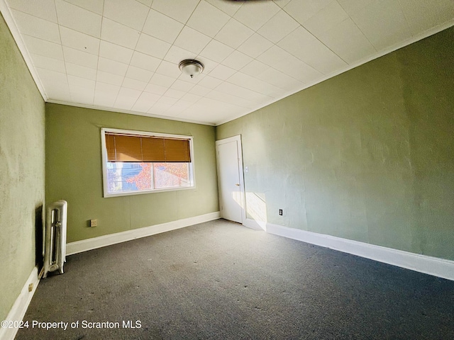 carpeted empty room featuring radiator heating unit and crown molding