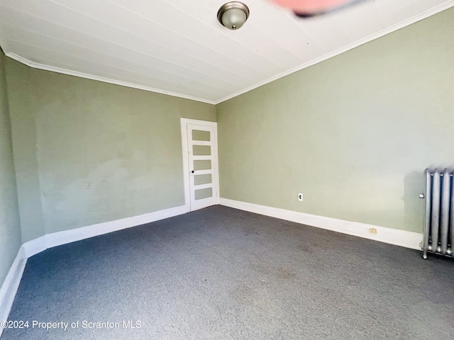 spare room with carpet floors, ornamental molding, and radiator