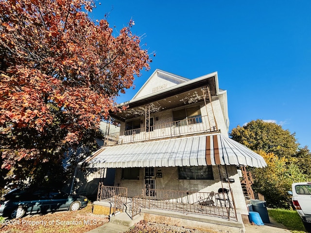 view of front facade featuring covered porch and a balcony