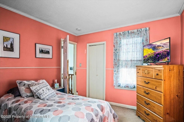 carpeted bedroom with crown molding, baseboards, a closet, and a textured ceiling