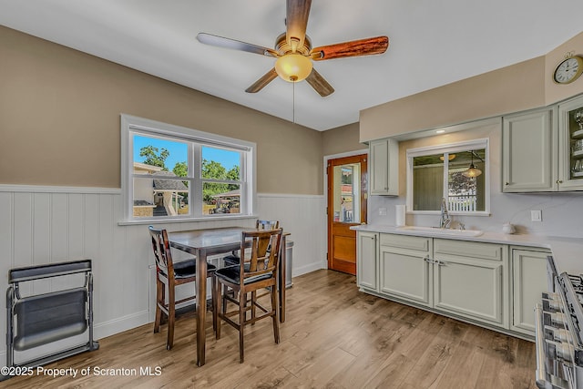 201 Franklin St, Dunmore, PA 18512 - kitchen featuring wainscoting, a ceiling fan, light wood-type flooring, stainless steel range with gas stovetop, and light countertops