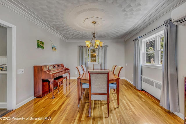 201 Franklin St, Dunmore, PA 18512 - dining area with a chandelier, radiator, an AC wall unit, light wood-type flooring, and ornamental molding