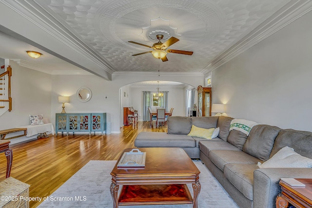 201 Franklin St, Dunmore, PA 18512 - living area featuring arched walkways, wood finished floors, a ceiling fan, crown molding, and stairway