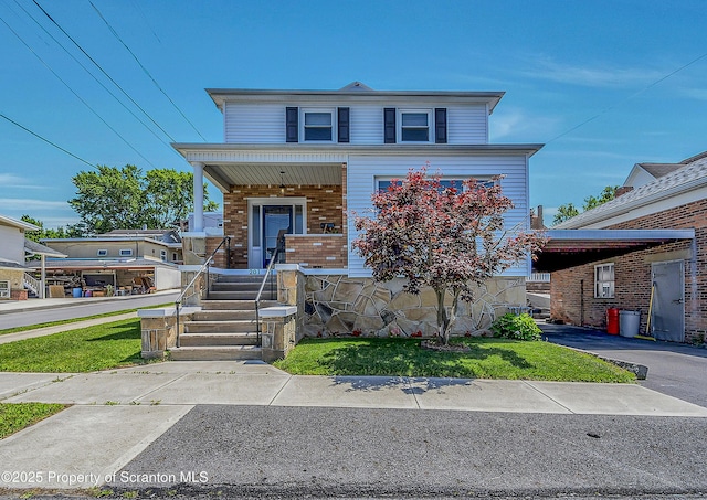 201 Franklin St, Dunmore, PA 18512 - view of front facade featuring a porch, brick siding, and a front lawn