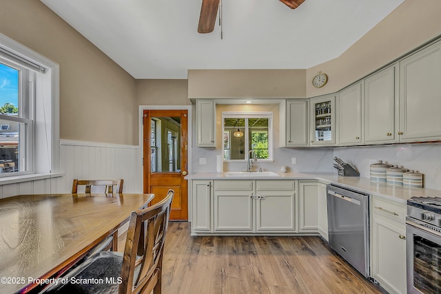 201 Franklin St, Dunmore, PA 18512 - kitchen with appliances with stainless steel finishes, light countertops, a ceiling fan, a wainscoted wall, and wood finished floors