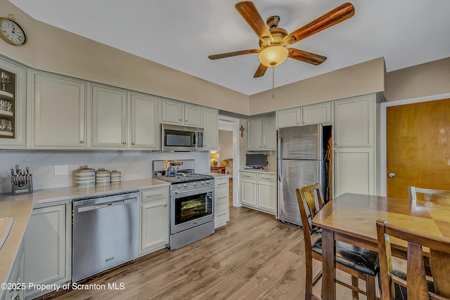 201 Franklin St, Dunmore, PA 18512 - kitchen featuring stainless steel appliances, ceiling fan, light countertops, light wood finished floors, and glass insert cabinets