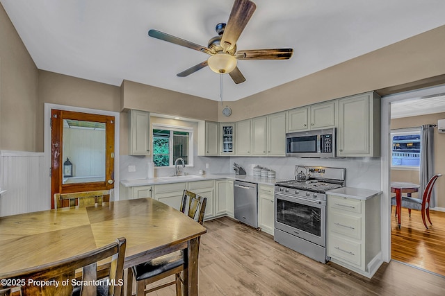 201 Franklin St, Dunmore, PA 18512 - kitchen with stainless steel appliances, light countertops, ceiling fan, light wood-style floors, and glass insert cabinets