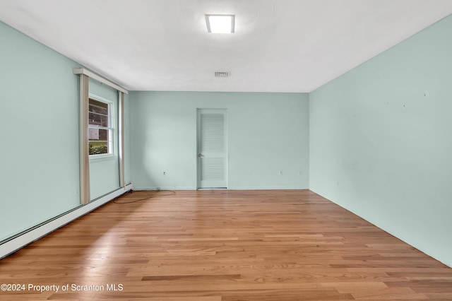 unfurnished room with light wood-type flooring and baseboard heating