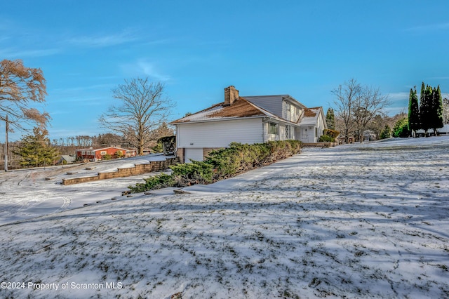 snow covered property featuring a garage