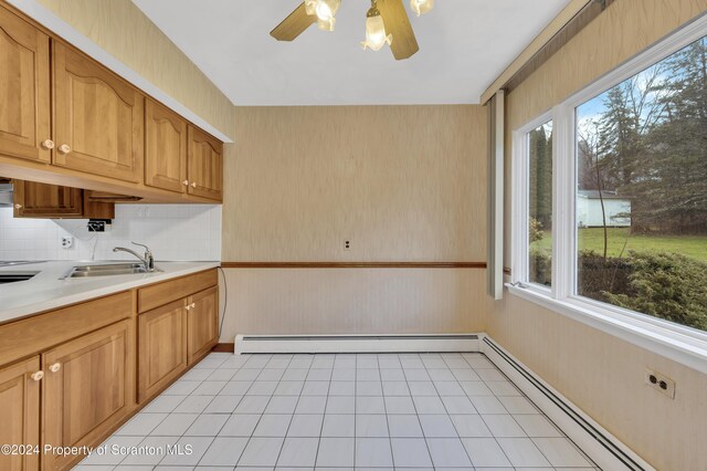 kitchen featuring light tile patterned flooring, ceiling fan, a baseboard heating unit, and sink