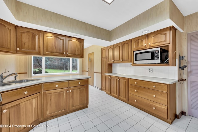 kitchen with light tile patterned floors, sink, and tasteful backsplash