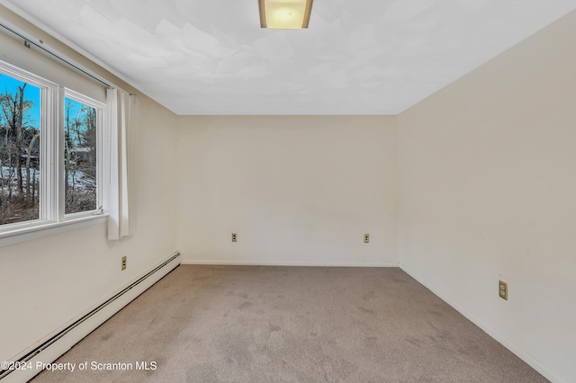 spare room with light carpet and a baseboard radiator