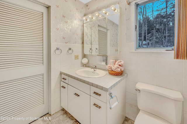 bathroom featuring vanity, a healthy amount of sunlight, and toilet