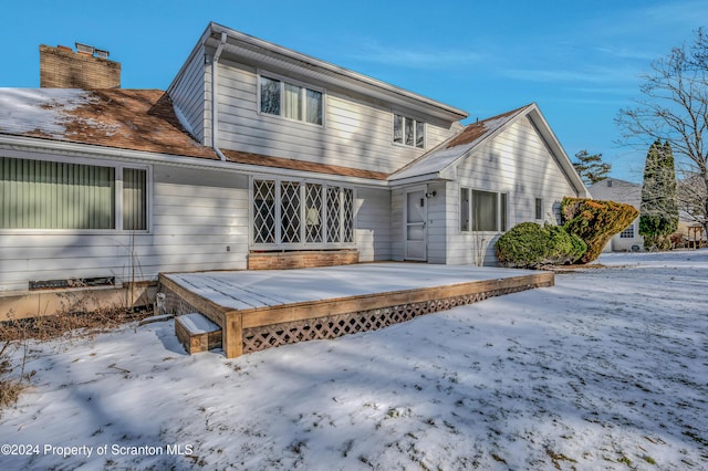 snow covered property featuring a wooden deck