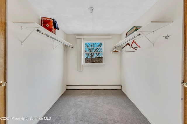 spacious closet featuring baseboard heating and carpet floors