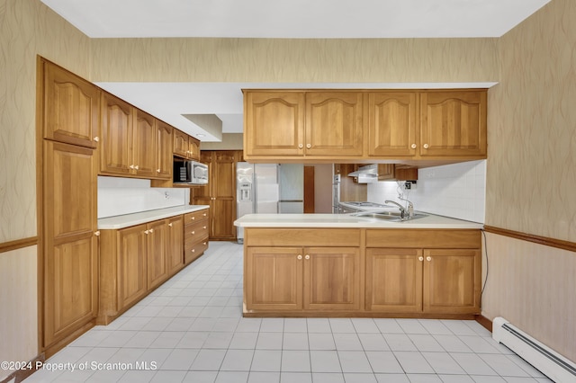 kitchen with kitchen peninsula, backsplash, stainless steel appliances, baseboard heating, and sink