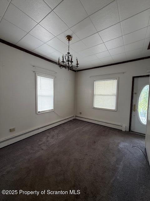 554 Back St, Scranton, PA 18504 - spare room featuring dark carpet, healthy amount of natural light, a chandelier, a baseboard radiator, and crown molding