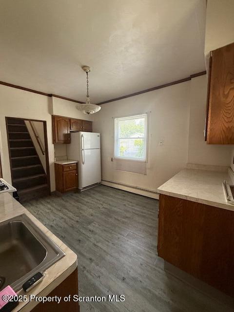554 Back St, Scranton, PA 18504 - kitchen with freestanding refrigerator, baseboard heating, crown molding, dark wood-style flooring, and light countertops