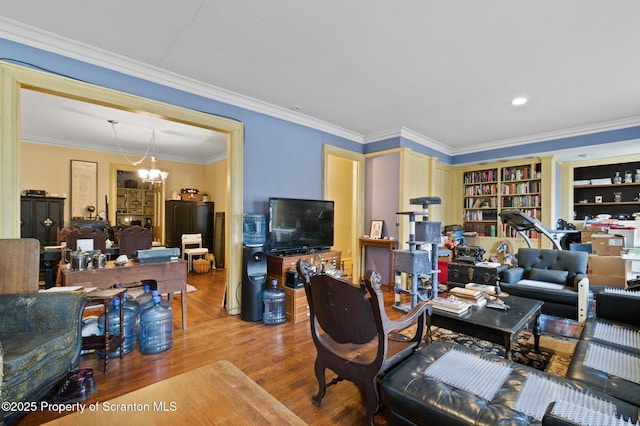 living area featuring ornamental molding, wood finished floors, and a chandelier