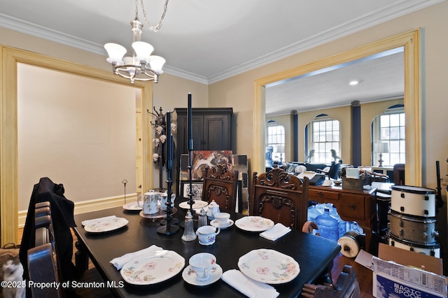 dining room with wood finished floors, an inviting chandelier, and ornamental molding