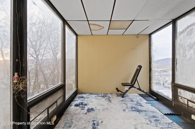 unfurnished sunroom with a drop ceiling and a mountain view