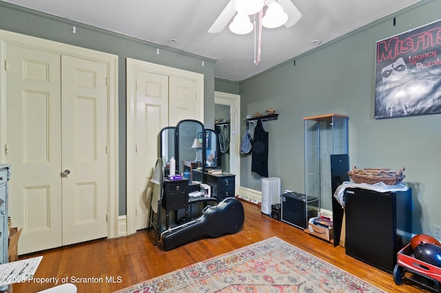 bedroom featuring radiator, wood finished floors, and ceiling fan