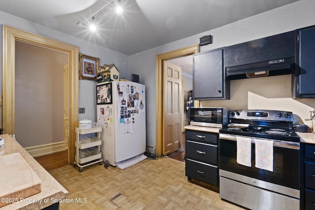 kitchen with light countertops, dark cabinets, under cabinet range hood, and stainless steel appliances