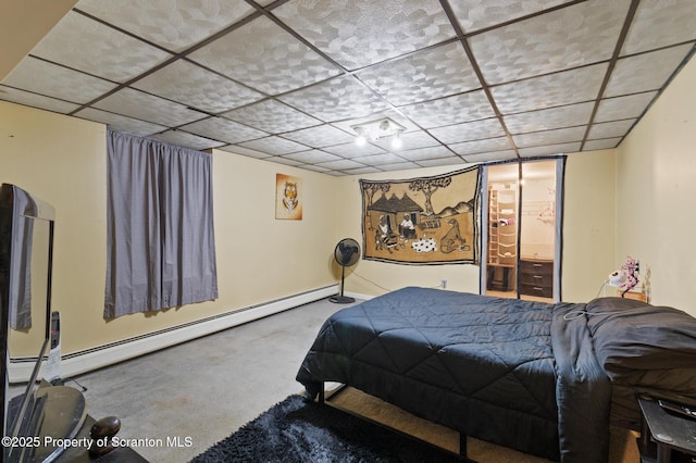 carpeted bedroom with a drop ceiling and baseboard heating