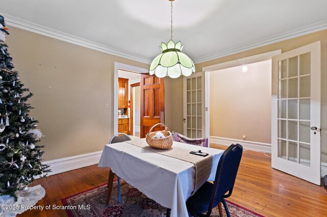 dining room featuring french doors, baseboards, ornamental molding, and hardwood / wood-style flooring