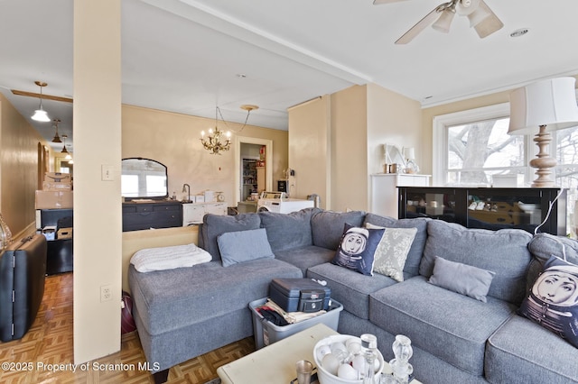 living area featuring ceiling fan with notable chandelier