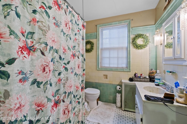 bathroom with vanity, curtained shower, tile walls, toilet, and tile patterned floors