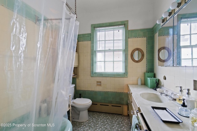 full bath featuring tile patterned floors, toilet, tile walls, a baseboard radiator, and vanity