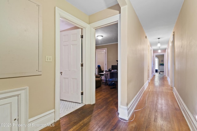 corridor with baseboards and hardwood / wood-style flooring