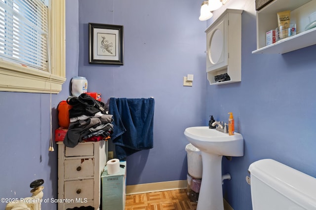 half bathroom featuring baseboards and toilet