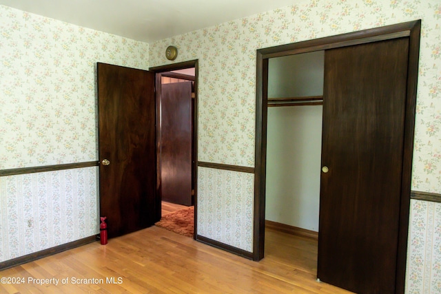 unfurnished bedroom with light hardwood / wood-style floors and a closet