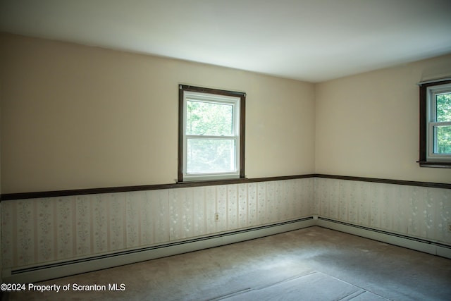 unfurnished room with carpet floors and baseboard heating