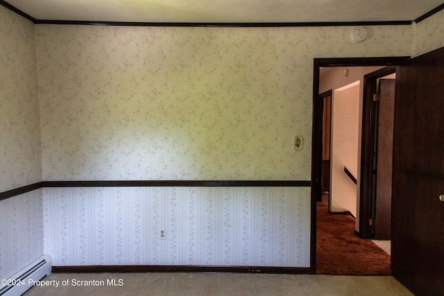 empty room with carpet flooring, crown molding, and baseboard heating