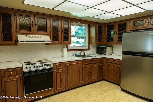 kitchen featuring electric stove, stainless steel fridge, sink, and extractor fan