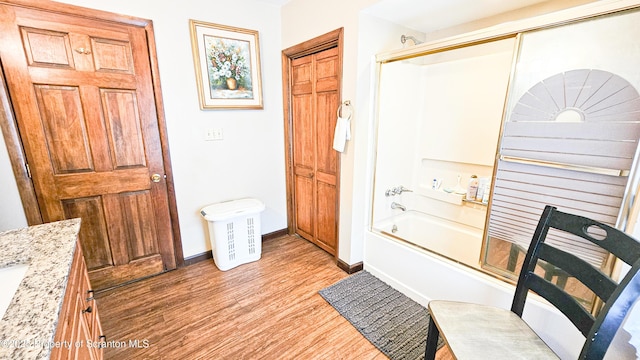 bathroom featuring bath / shower combo with glass door, vanity, and wood-type flooring