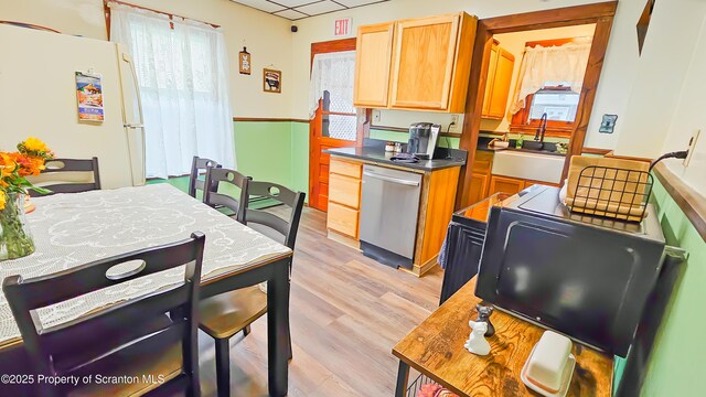 kitchen featuring a drop ceiling, sink, white refrigerator, light hardwood / wood-style flooring, and dishwasher