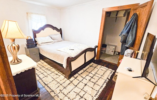 bedroom with a closet, dark hardwood / wood-style flooring, and ornamental molding